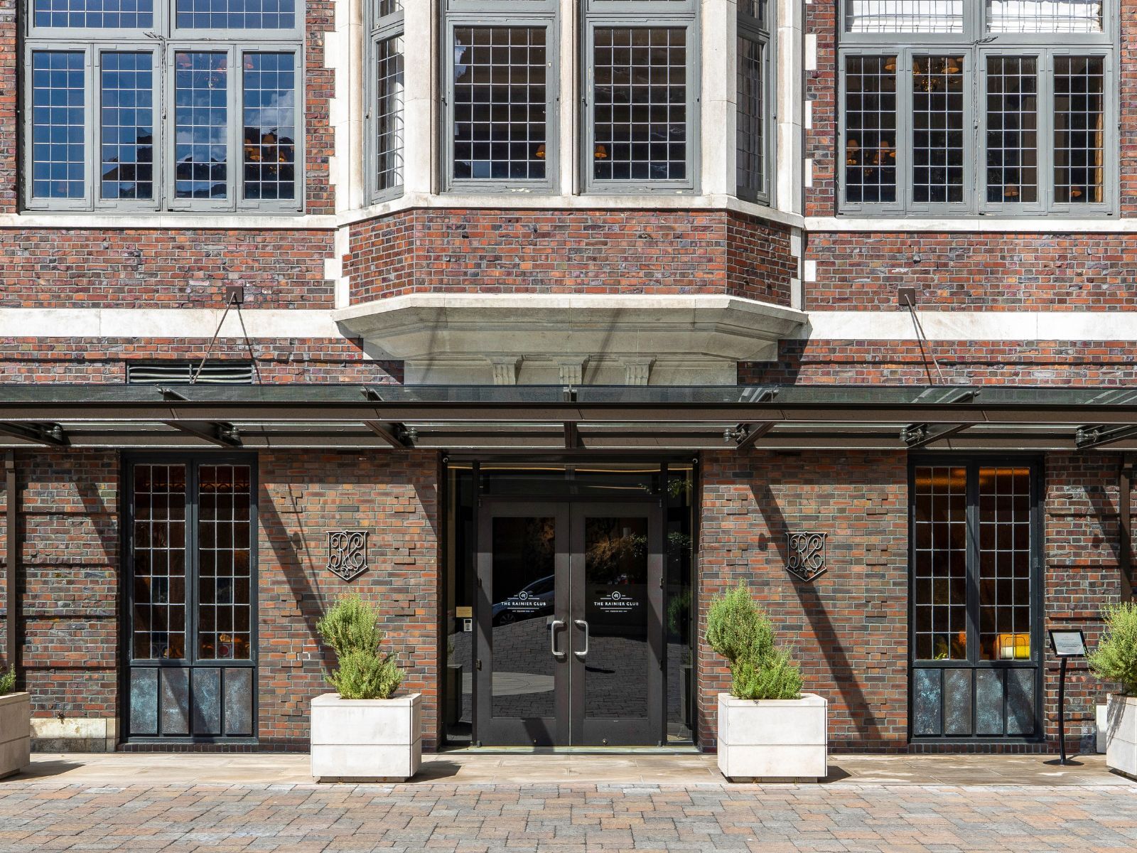 The historic brick clubhouse entrance on Fourth Avenue with the Club's crests
